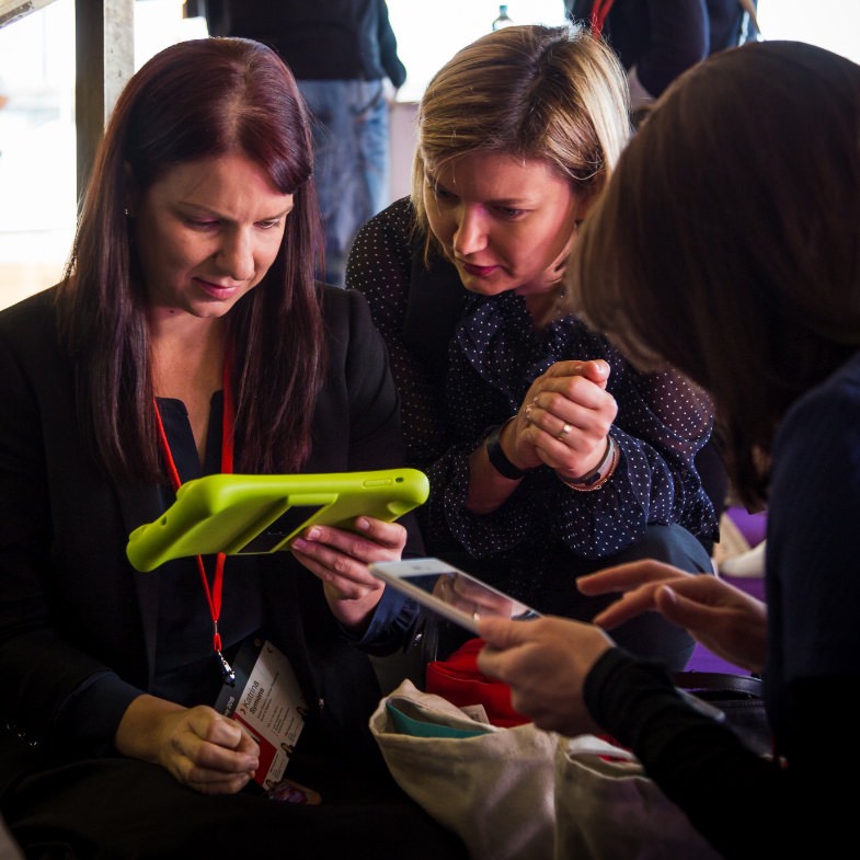 women looking at their devices